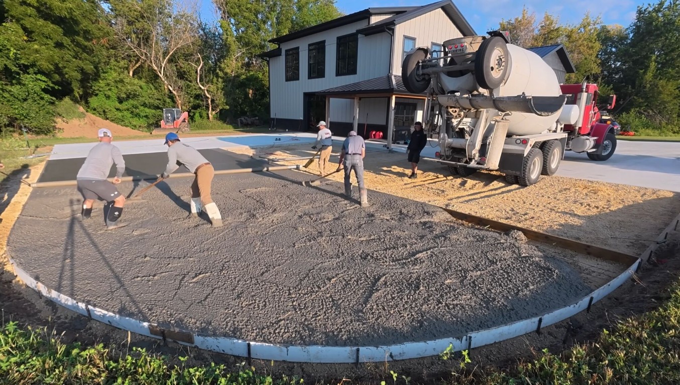 Concrete crew pouring a large commercial concrete driveway with a cement truck