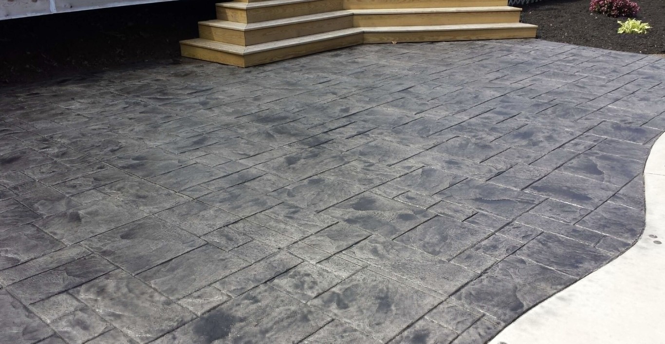 Stamped concrete patio with stone pattern finish in dark gray